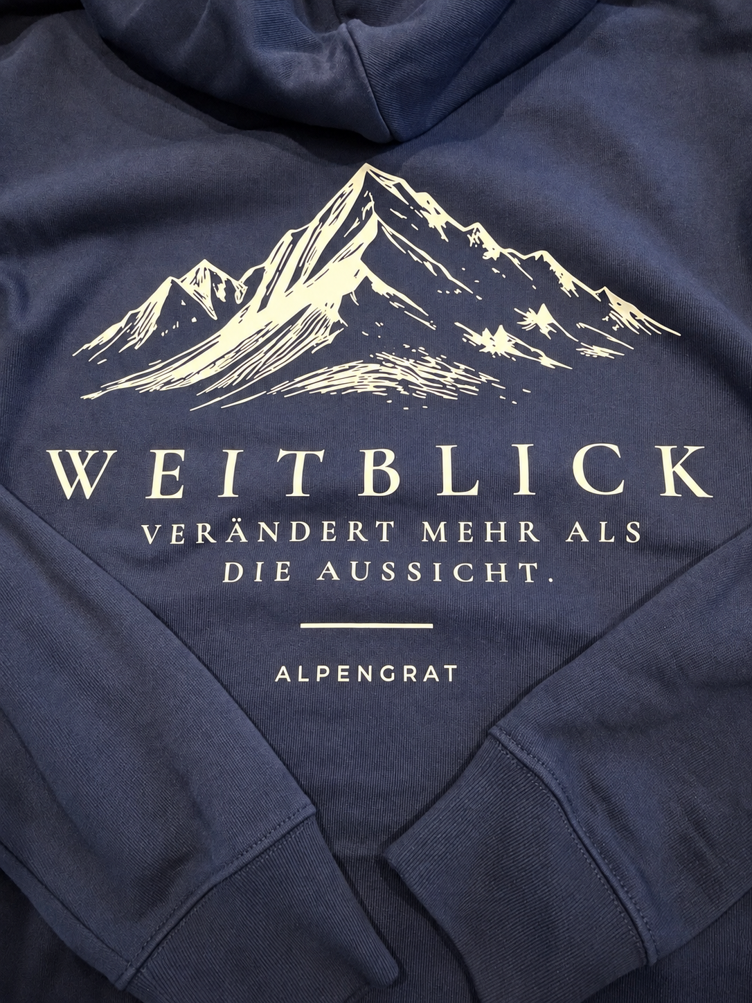 Weitblick-Hoodie in Bergsee mit cremefarbenem Bergmotiv und Rückenprint – Detailaufnahme
